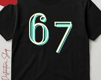 May include: Black t-shirt with the number "67" in a retro font. The number is outlined in light blue and white. The shirt also has the text "BLACK Color" and "MADE / PRINTED USA".