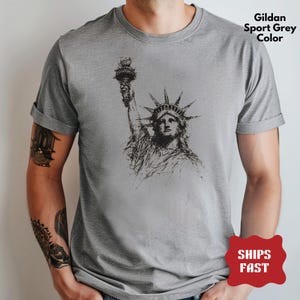 Statue of Liberty graphic t-shirt featuring a patriotic vintage-style New York design, perfect for American pride and freedom lovers.