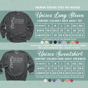 以下が含まれることがあります： チャコールグレーの長袖Tシャツとクルーネックのスウェットシャツ。どちらも白いユリのイラストと「AND FOR THE LADY, PERHAPS REVENGE?」というテキストがプリントされています。インチ単位の幅と長さが記載されたサイズ表が含まれています。