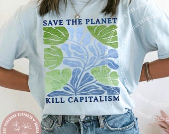 May include: Light blue t-shirt with the text "SAVE THE PLANET" and "KILL CAPITALISM" in dark blue. The shirt features a floral design in green and blue. The word "CHAMBRAY" is printed at the bottom.