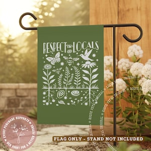 May include: A green garden flag with the words "Respect the Locals" in white, along with illustrations of a butterfly, bee, hummingbird, and flowers. The flag is displayed on a black metal stand. A circular logo is in the lower left corner.