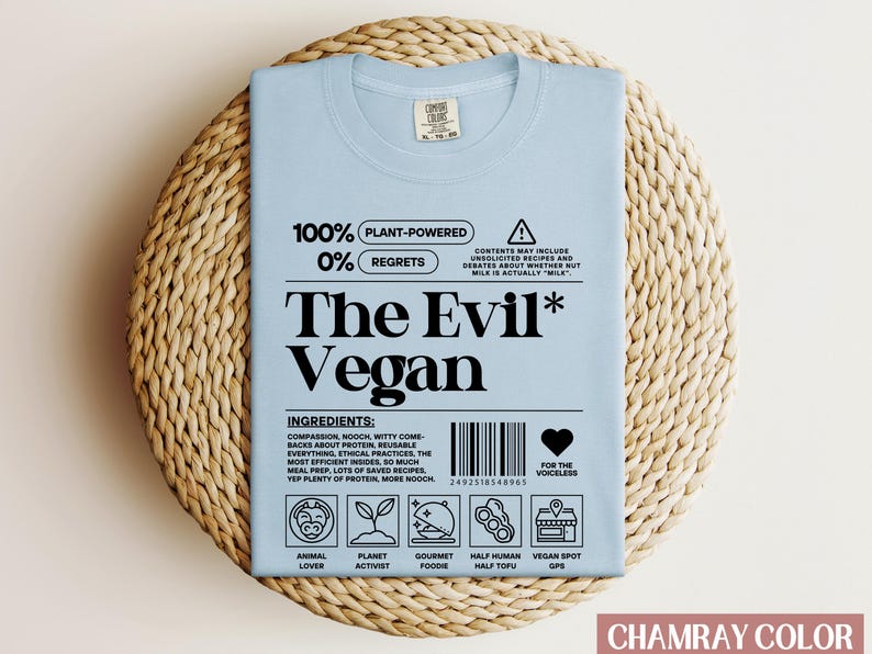 May include: Light blue t-shirt with a white graphic design that says "100% Plant-Powered 0% Regrets The Evil* Vegan" with a barcode and icons below the text. The icons represent animal lover, planet activist, gourmet foodie, half human half tofu, and vegan spot GPS.