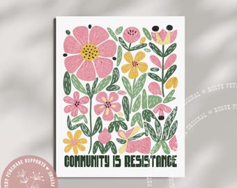 May include: A floral art print featuring pink and yellow flowers with green leaves on a white background. The text "COMMUNITY IS RESISTANCE" is displayed in a bold, dark green font. A circular logo with text and floral design is in the lower left corner.