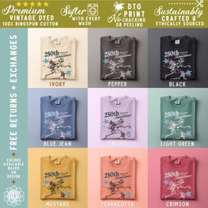 May include: A collection of folded t-shirts in various colors, including ivory, pepper, and black. Each shirt features a graphic commemorating the 250th Anniversary of Independence. The shirts are made of premium vintage-dyed 100% ringspun cotton.