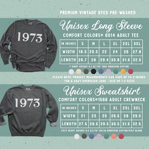May include: A charcoal gray long-sleeve shirt and a charcoal gray sweatshirt, both featuring the white text 1973. The image includes two sizing charts with width and length measurements in inches for Comfort Colors 6014 and 1566 models.