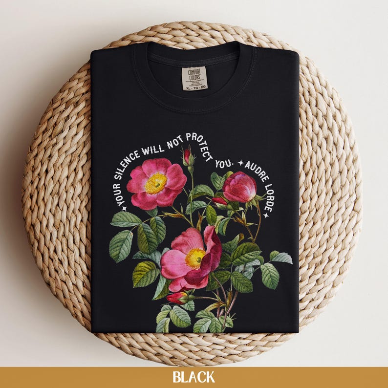 May include: Black t-shirt with a floral design and the quote "Your silence will not protect you. - Audre Lorde" printed in white.
