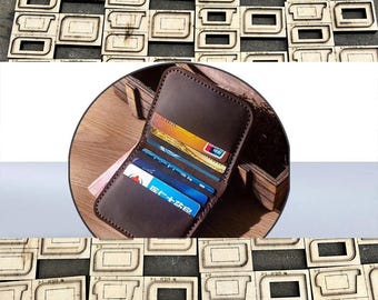 May include: A brown leather wallet filled with credit cards and cash. The wallet is open, displaying multiple card slots. Surrounding the wallet are several wooden die-cut templates, likely for leather crafting.