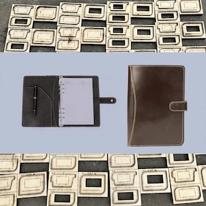 May include: A brown leather binder with a pen and notepad, shown open and closed. The open binder reveals a pen in a pocket and a notepad. The closed binder has a clasp. Wooden die-cut shapes are in the background.