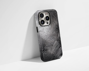 Puede incluir: Una funda para smartphone con un patrón de mapa topográfico en blanco y negro de alto contraste con líneas fluidas y arremolinadas. La funda tiene un recorte para un sistema de cámara de triple lente en la parte posterior del dispositivo.