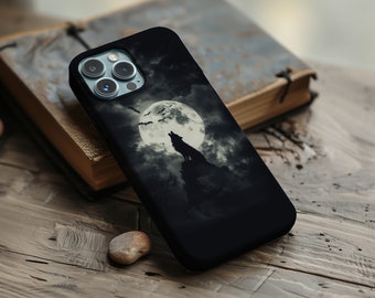 Puede incluir: Una funda de teléfono negra con un lobo aullando a la luna. La luna está llena y es blanca, y el cielo está oscuro y nublado. Hay murciélagos volando alrededor de la luna.