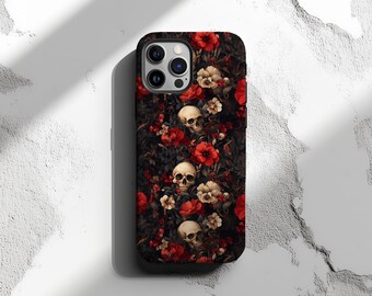 Puede incluir: Una funda de teléfono negra con un patrón floral con flores rojas y calaveras blancas. La funda tiene un recorte para el objetivo de la cámara y un borde negro.