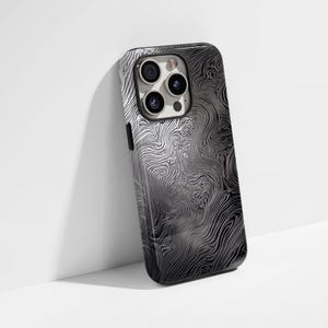 May include: A black phone case with a white swirling pattern. The case has a camera lens cutout with three lenses.
