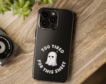 Puede incluir: Carcasa de teléfono negra con un fantasma blanco y el texto "Too Tired For This Sheet".
