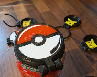 Peut inclure: Une canette rouge et blanche sur le thème de Pokémon avec un couvercle noir et un dessous de verre assorti. La canette présente une étiquette Monster Zero. Plusieurs dessous de verre noirs avec des motifs Pikachu sont éparpillés autour de la canette. Le couvercle a un design de Poké Ball.