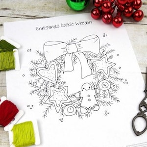 May include: A black and white printable design of a Christmas cookie wreath. The wreath is made of cookies shaped like stars, hearts, and gingerbread people. The wreath is decorated with a bow and a few ornaments. The text "Christmas Cookie Wreath" is at the top of the page.