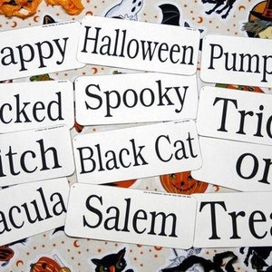 Könnte beinhalten: Eine Ansammlung weißer, rechteckiger Schilder mit schwarzem Text, die Halloween-Wörter wie "Happy", "Halloween", "Pumpkin", "Wicked", "Spooky", "Witch", "Black Cat", "Dracula", "Salem", "Trick", "Or" und "Treat" zeigen.