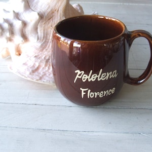 May include: A brown ceramic mug with white lettering that reads "Pololena Florence".