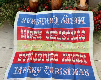 May include: A vintage Christmas-themed handkerchief with a red, white, and blue design. The handkerchief has the words "Merry Christmas" and "Happy New Year" printed on it.
