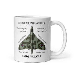 May include: White ceramic mug with an Avro Vulcan bomber design in camouflage. Text reads "COLD WAR AND FALKLANDS LEGEND" and technical details. A great gift for aviation fans. The mug is a standard size.