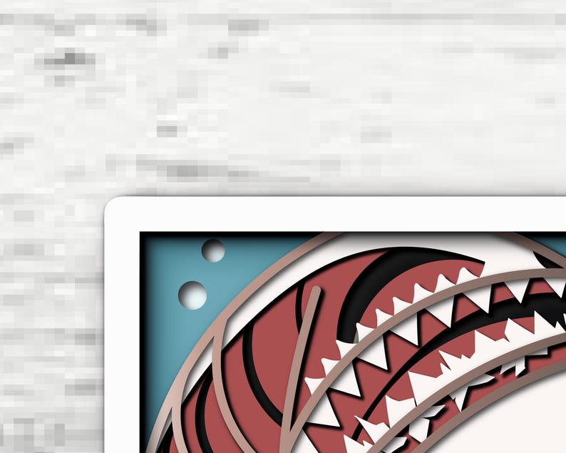 May include: A layered paper art piece featuring a stylized red and white shark mouth with sharp teeth. The design includes a blue background with two circular cutouts, creating a dimensional effect with stacked paper layers in red, white, and blue.