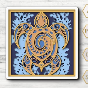 May include: A layered paper art piece featuring a stylized sea turtle design. The artwork uses shades of gold, blue, and white, with intricate cut-out details. The turtle is centered within a square frame, with a light blue background.
