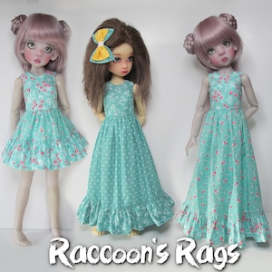 May include: Three dolls wearing different variations of a teal blue and white floral print dress. The dolls have pink hair and are standing on a white background. The text "Raccoon's Rags" is at the bottom of the image.