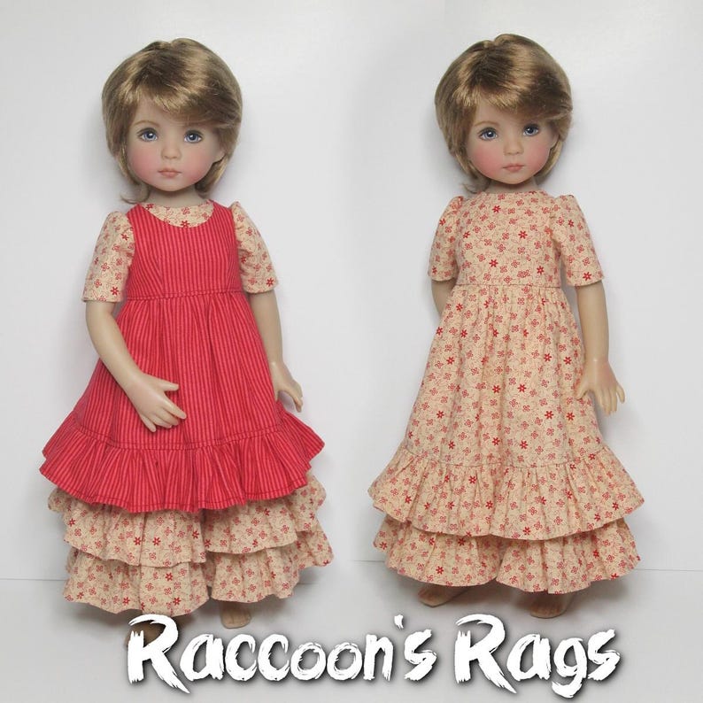 K&ouml;nnte beinhalten: Zwei Puppen in handgefertigten Kleidern. Eine Puppe tr&auml;gt ein rot gestreiftes Kleid mit R&uuml;schenrock. Die andere Puppe tr&auml;gt ein Blumenkleid mit R&uuml;schenrock. Die Kleider sind von Raccoon's Rags.