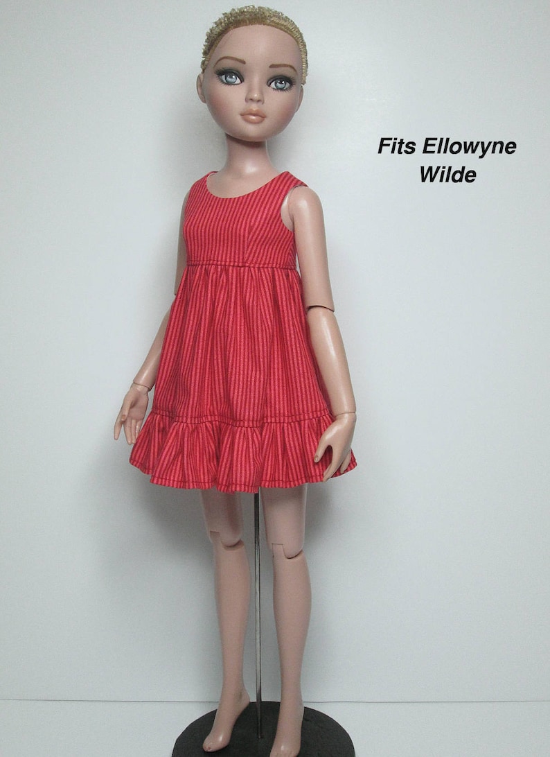 K&ouml;nnte beinhalten: Ein rotes gestreiftes Puppenkleid mit R&uuml;schensaum. Das &auml;rmellose Kleid wird an einer Puppe mit blonden Haaren und blauen Augen gezeigt. Der Text "Fits Ellowyne Wilde" ist auf der rechten Seite des Bildes zu sehen.
