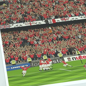 May include: A digital illustration of a football match with a team celebrating a goal. The players are wearing white shirts with red numbers and black shorts. The crowd is cheering in the background. The words "UMBRO", "for esta", and "nute" are visible on the pitch.