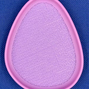 May include: A light purple, oval-shaped, textured dish with a raised rim.