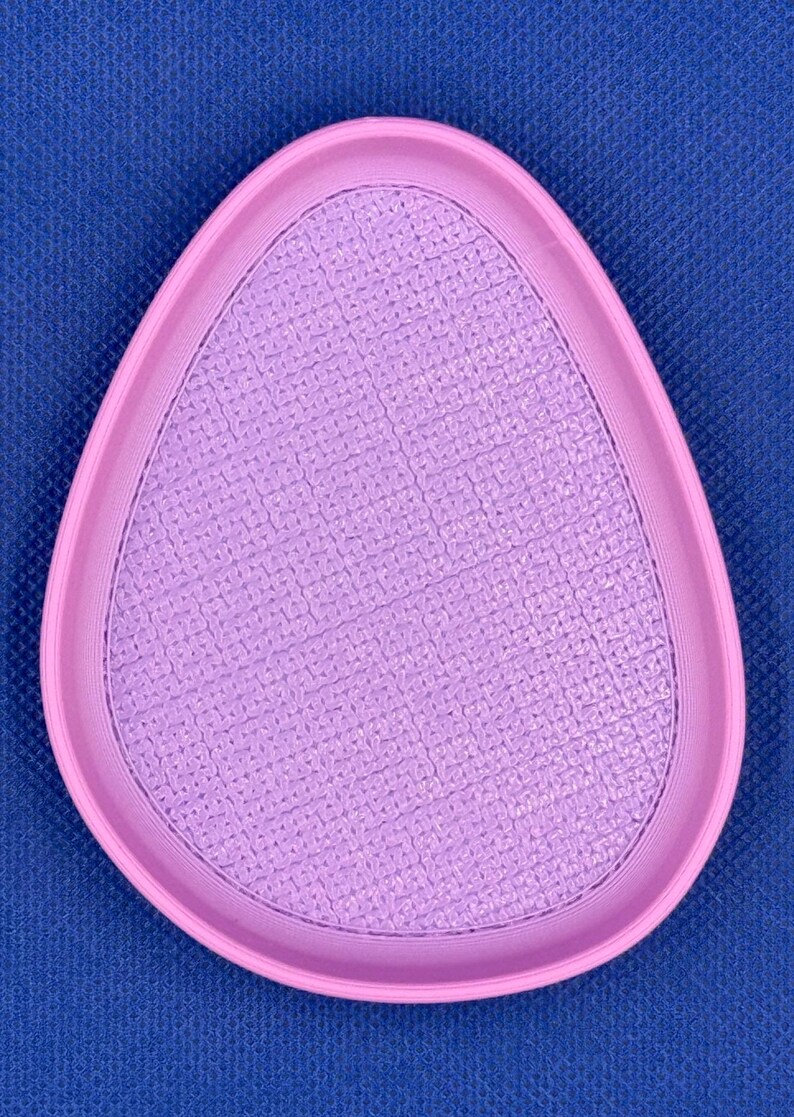 May include: A light purple, oval-shaped, textured dish with a raised rim.