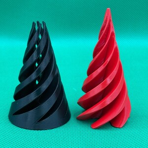May include: Two 3D printed conical objects with a spiral design. One object is solid black and the other is solid red. Both items feature a series of curved, vertical fins that taper toward the top, creating a hollow, open-frame structure.