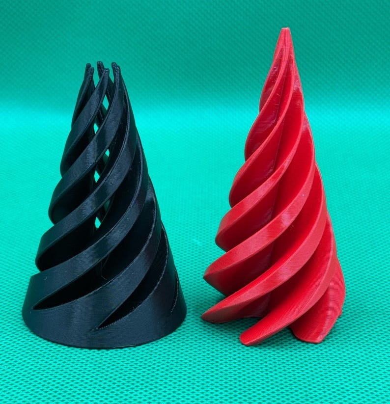 May include: Two 3D printed conical objects with a spiral design. One object is solid black and the other is solid red. Both items feature a series of curved, vertical fins that taper toward the top, creating a hollow, open-frame structure.