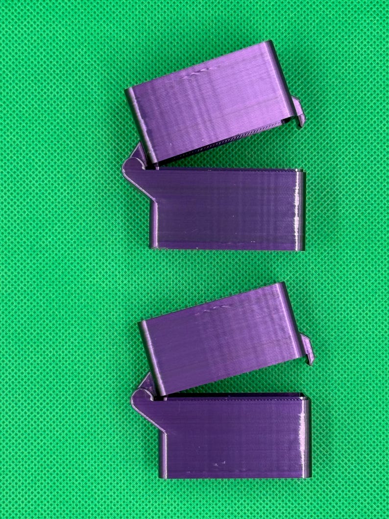 May include: Three purple 3D printed boxes with hinged lids. The boxes are stacked on top of each other.