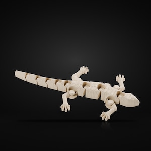 Puede incluir: Una figura de lagarto articulada de madera de color claro con un diseño de cuerpo y cola segmentados. El lagarto tiene cuatro pies detallados con dedos visibles y una superficie texturizada, mostrando una estructura flexible.