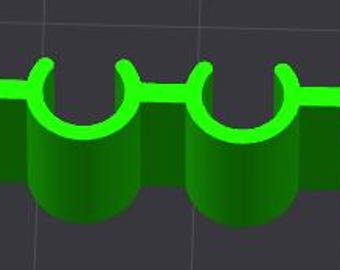 May include: A 3D-rendered, bright green object with four cylindrical sections connected by a flat, horizontal bar. Each cylinder has a curved top, creating a series of four connected arches. The object is set against a dark gray background.