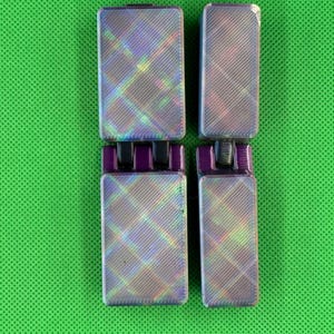 May include: Four iridescent purple and grey rectangular blocks with a chequered pattern. The blocks are arranged in two pairs, stacked on top of each other.