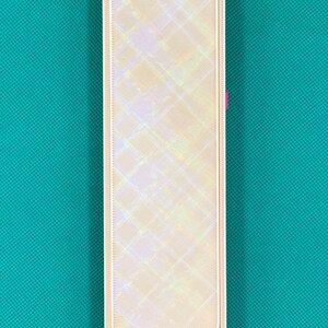 May include: A rectangular storage case with a sliding lid featuring a pearlescent, iridescent finish with a diagonal grid pattern. The base of the case is a solid, vibrant magenta pink color, visible at the bottom where the lid is partially open.
