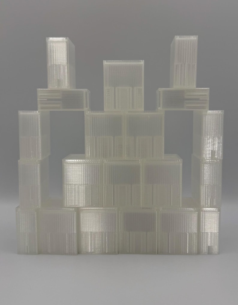 May include: A collection of translucent, rectangular plastic storage containers stacked in a pyramid formation. Each container features a ribbed, vertical texture on the exterior surface and a clear, semi-transparent finish throughout the structure.