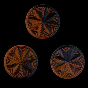 May include: Three circular wooden coasters featuring a complex, layered geometric pattern in alternating shades of deep orange, brown, and dark charcoal gray. Each coaster displays a radial, star-like design with carved, textured grooves.