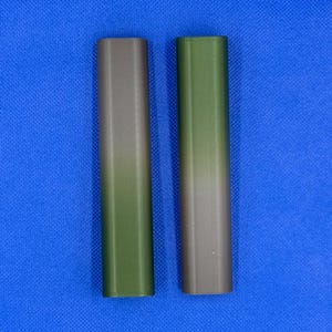 May include: Two cylindrical tubes with a gradient color design. The tube on the left is a dark green to brown gradient. The tube on the right is a dark brown to green gradient.