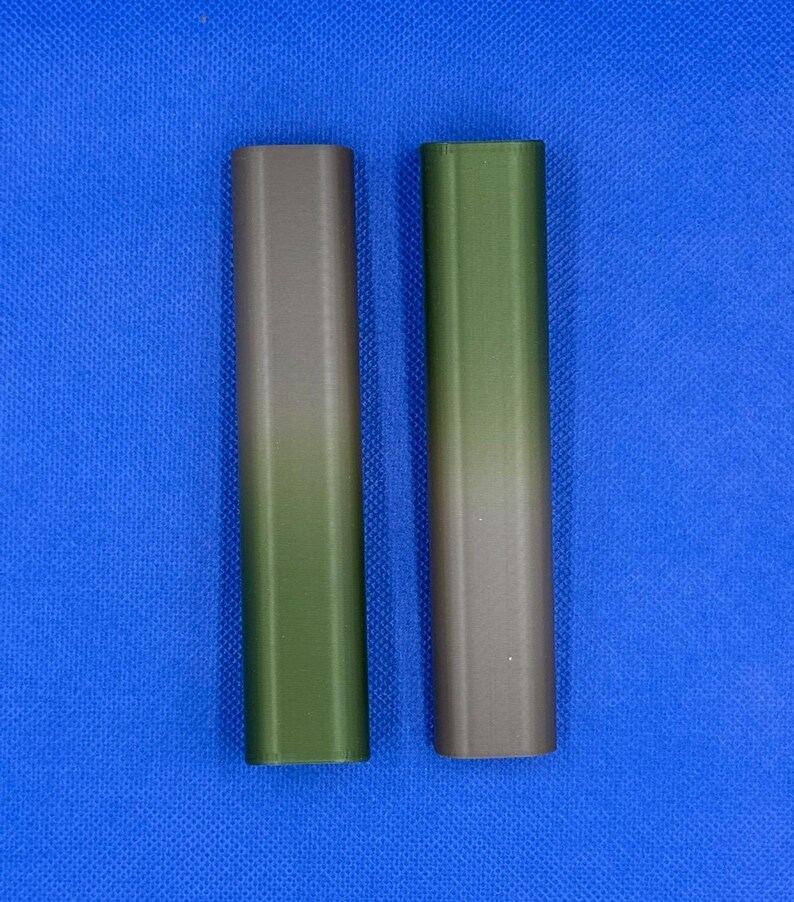 May include: Two cylindrical tubes with a gradient color design. The tube on the left is a dark green to brown gradient. The tube on the right is a dark brown to green gradient.