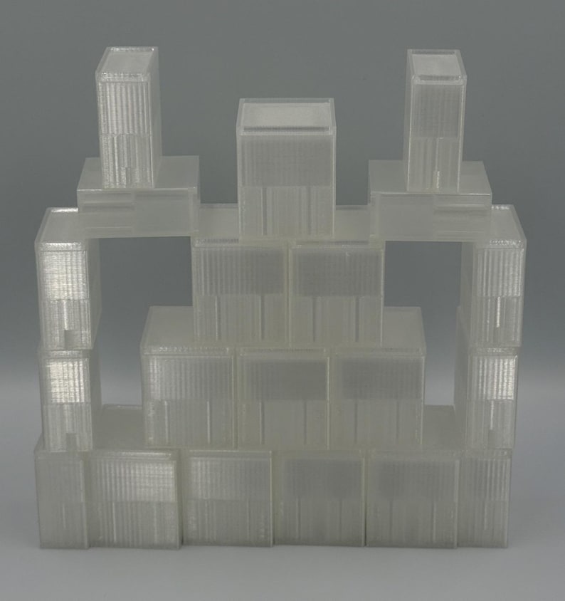 May include: A collection of translucent, rectangular plastic storage containers stacked in a pyramid formation. Each container features a clear, ribbed exterior surface with a smooth, flat lid, creating a uniform and modular storage system.