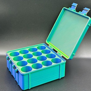 May include: A teal and green plastic storage box with a hinged lid and 12 compartments. The box is open and the lid is propped up.