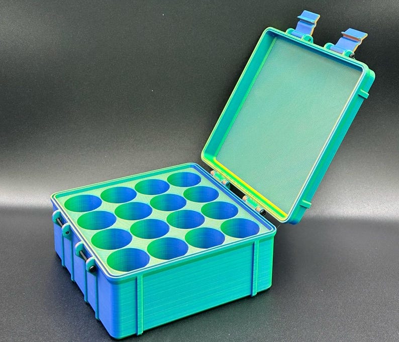 May include: A teal and green plastic storage box with a hinged lid and 12 compartments. The box is open and the lid is propped up.