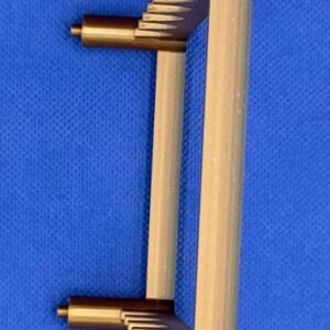K&ouml;nnte beinhalten: Ein goldfarbener Plastikst&auml;nder mit rechteckiger Form und einem Gittermuster oben und unten. Der St&auml;nder hat vier Beine.
