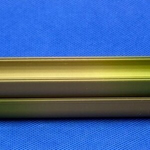 May include: Two stacked, green, metal, rectangular containers with rounded edges. The containers are open on one side and have a slight gradient of color from dark green to light green.