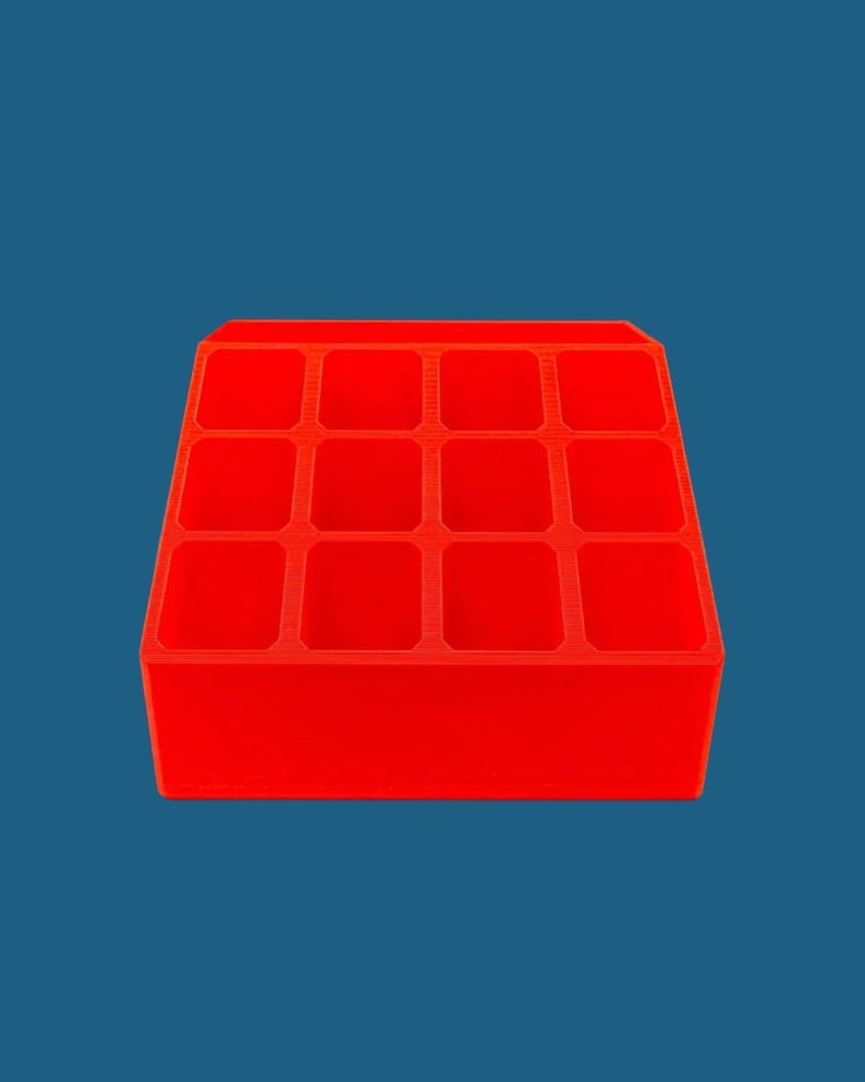 May include: A bright red plastic organizer with 12 compartments. The organizer is perfect for storing small items like jewelry, craft supplies, or office supplies.