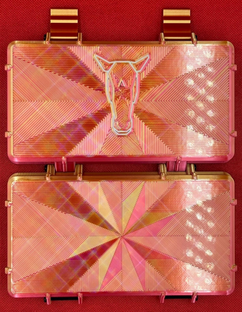 May include: Two gold-toned metal plates with a geometric pattern. The top plate features a stylized horse head design.