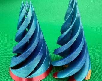May include: Two blue and gold 3D printed spiral ornaments with a red base. The ornaments are made of plastic and have a shiny finish.